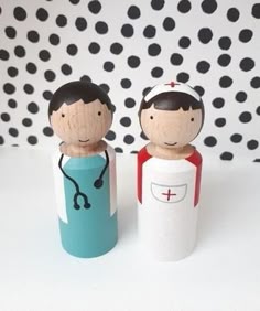 two wooden dolls are standing next to each other