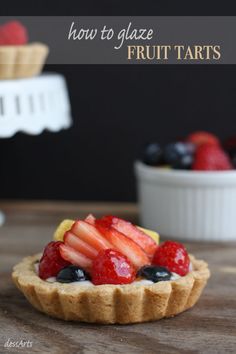 a fruit tart is sitting on a wooden table