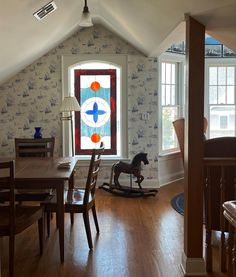 room in victorian beach house with a stained glass window, vintage furniture, and ship patterned wallpaper