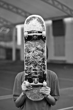 a person holding a skateboard over their face