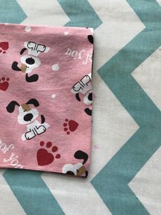 a pink and black dog paw print blanket on top of a chevron blue and white background
