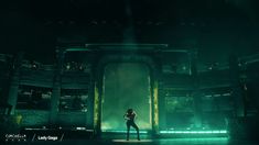a person standing in front of a stage with green lights on the walls and floor