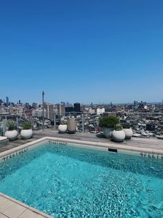 an empty swimming pool on the roof of a building with city skyline in the background