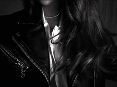 a woman with long hair wearing a black leather jacket