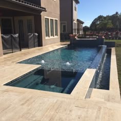 an empty swimming pool in front of a house