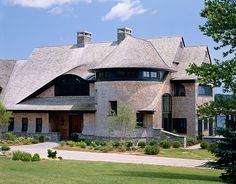 a large brick house with two story windows on the top floor and an arched roof