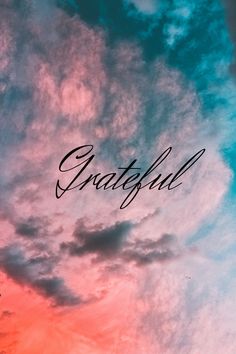 the word grateful written in cursive writing against a colorful sky