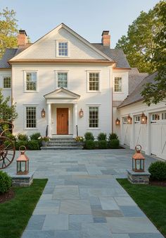 a large white house with two lanterns on the front and one light on the side