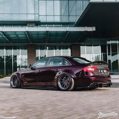 a maroon car parked in front of a building