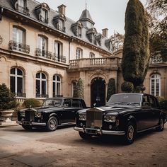 two black rolls royces parked in front of a mansion