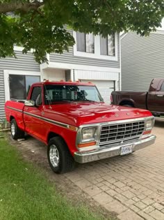 a red pick up truck parked in front of a house