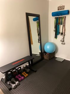 a room with a mirror, gym equipment and a blue ball
