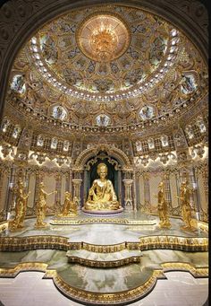 the inside of a building with gold statues on it's walls and an ornate ceiling