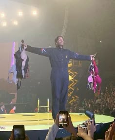 a man standing on top of a stage with his arms outstretched