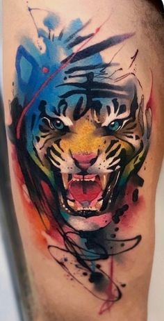a colorful tiger tattoo on the leg with ink splatters and paint splashes