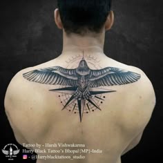 the back of a man's neck with a bird on it and compass tattoo