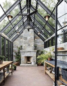 the inside of a glass house with an outdoor fireplace