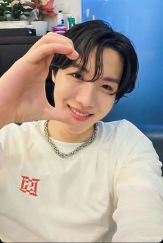 a young man sitting in front of a computer desk with his hand on the top of his head