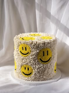 a cake with yellow and white frosting has smiley faces on it