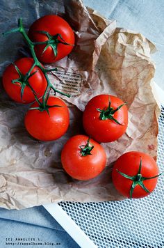 five tomatoes sitting on top of a piece of paper