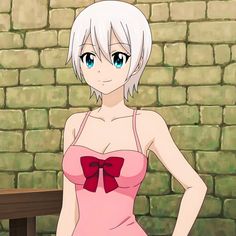 a woman in a pink dress standing next to a brick wall with her hands on her hips