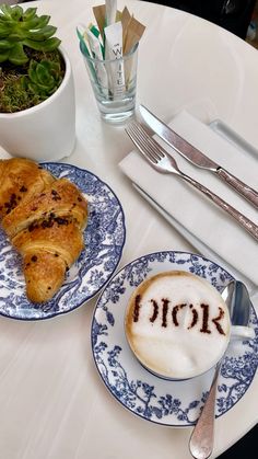 two blue and white plates with food on them next to utensils, silverware