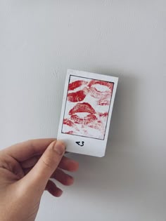 a hand holding a card with lipstick prints on it