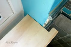a piece of wood sitting on top of a wooden table next to a blue wall
