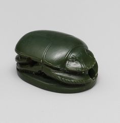 a green plastic turtle toy on a white surface