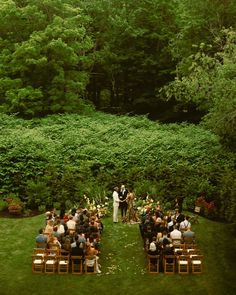 an outdoor ceremony in the middle of a lush green field with lots of greenery