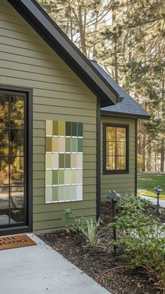 a house that has some paint samples on the side of it and trees in the background