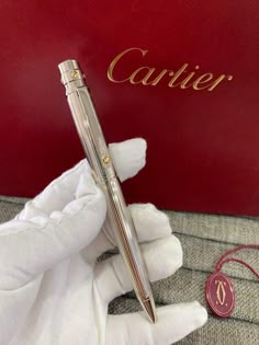a pen sitting on top of a red box next to a pair of white gloves