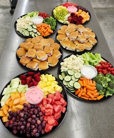 several plates filled with different types of food on top of a metal counter next to each other