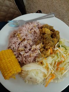 a white plate topped with rice, corn and meat