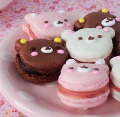 a pink plate topped with lots of different types of donuts on top of a table