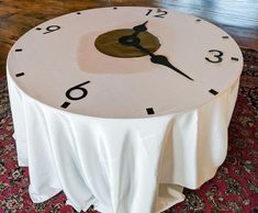a round table with a clock on it sitting in front of a red carpeted floor