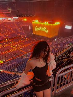 a woman standing in front of an empty stadium