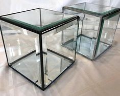 two glass cubes sitting on top of a white floor next to eachother