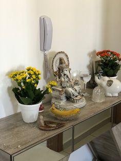 a table topped with vases filled with flowers and an elephant figurine on top of it
