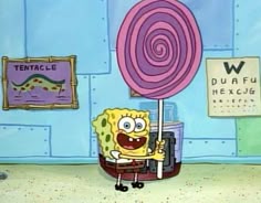 a cartoon character holding a giant lollipop in front of a wall with other signs