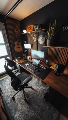 a desk with a laptop computer on top of it next to a guitar and other items