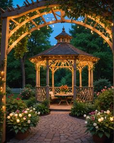a gazebo surrounded by flowers and lights