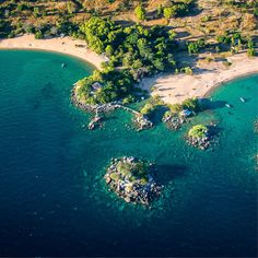 an aerial view of the beach and surrounding area with several small islands in the water