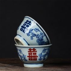 two blue and white dishes sitting on top of a wooden table next to each other