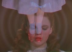 a woman with her hands on top of another woman's head while she is wearing red lipstick