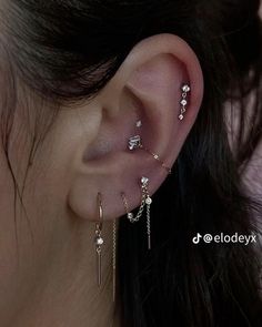 a woman wearing three different ear piercings
