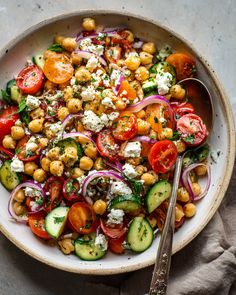 a salad with tomatoes, cucumbers, chickpeas and feta cheese