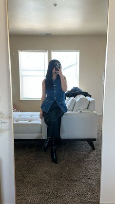 The perfect transitioning outfit into spring from the winter. A denim vest with black satin long skirt and a pair of black leather boots.