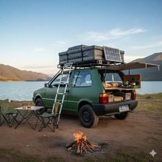a camper van is parked next to a fire pit with an open roof top