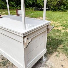 a large white box sitting on top of a grass covered field